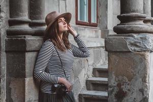 belle femme au chapeau prend une photo avec un appareil photo à l'ancienne