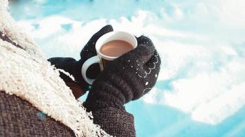 tasse chaude de café chaud réchauffant dans les mains d'une fille photo