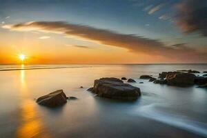 une longue exposition photographier de rochers sur le plage à le coucher du soleil. généré par ai photo