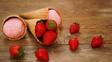 glace à la fraise dans un cornet gaufré. fruits rouges et boules de glace