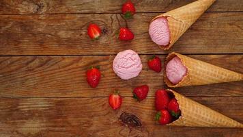 glace à la fraise dans un cornet gaufré. fruits rouges et boules de glace photo