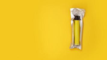 Cigarette électronique jetable jaune dans l'emballage sur fond jaune