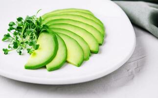 tranché Avocat sur blanc assiette photo