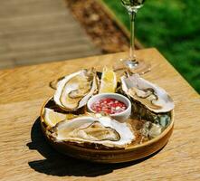 ouvert Huîtres et citron avec blanc du vin sur le table photo