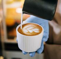 Lait mousse versé dans une tasse à forme une parfait cappuccino photo