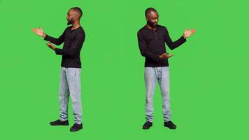africain américain homme création publicité dans studio, montrer du doigt à la gauche ou droite côtés pour un d présentation. Jeune Masculin modèle dans jeans et chemise en présentant quelque chose sur plein corps écran vert. photo