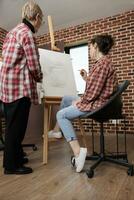 adulte fille et Sénior mère Faire art ensemble tandis que assister dessin atelier, apprentissage à dessiner, développement commun intérêts et loisirs. prof et étudiant à la recherche à Toile avec ouvrages d'art photo