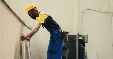 ingénieur démantèlement air Conditionneur à nettoyer ample débris accumulé à l'intérieur. capable spécialiste en train de préparer à nettoyer HVAC système corps et contrôle panneau avec saupoudrage brosse outil à retirer ample saleté photo