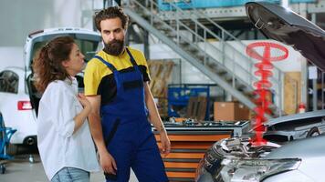 dépanneur dans réparation magasin en utilisant holographique augmenté réalité à spectacle client défectueux voiture piston. chevronné garage professionnel en utilisant Avancée ar technologie à projet voiture les pièces pour femme photo