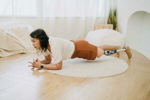prothétique jambe gens formation planches exercice à maison. invalidité asiatique femme soins de santé activité intérieur. photo