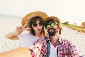 couple ou meilleur copains homme et femme ayant amusement sur été ensoleillé plage . portant paille chapeau, des lunettes de soleil, élégant chemises . photo