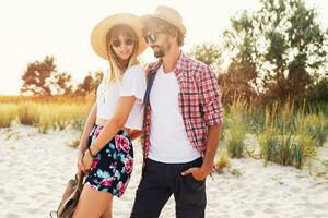 couple ou meilleur copains homme et femme ayant amusement sur été ensoleillé plage . portant paille chapeau, des lunettes de soleil, élégant chemises . photo