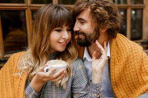 confortable chaud portrait de magnifique couple dans l'amour profiter romantique temps ensemble dans café. Beau homme avec entendu avec le sien élégant épouse étreindre. photo