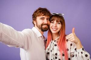 content couple dans l'amour fabrication soi portrait sur violet Contexte. photo