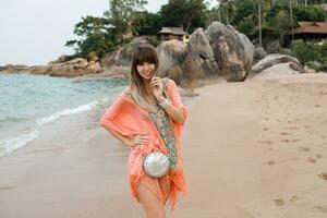 magnifique femme avec longue Cheveux dans élégant boho été robe posant sur le tropical plage. photo