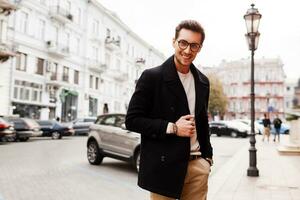 souriant magnifique Beau homme dans veste posant sur le rue. Masculin l'automne mode les tendances. photo