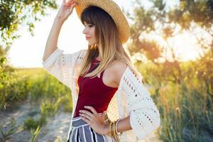 proche en haut été photo de jolie femme dans paille chapeau posif sur le plage à le coucher du soleil lumière.