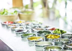 bols de poivrons rouges et de légumes biologiques frais mélangés dans un affichage de bar à salade moderne