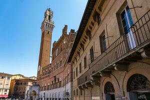 Sienne ,italie-août dix, 2020-personnes et touristes visite le célèbre piazza del campo et le torre del mangia pendant une ensoleillé journée photo