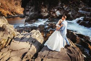 couple de mariage sur un fond de montagnes et de rivières dans les couchers de soleil photo