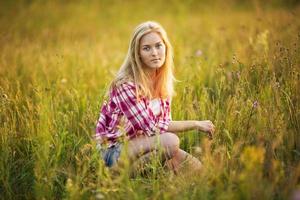 belle fille est assise dans l'herbe photo