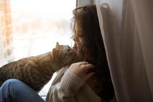 fille assise et caressée avec un chat photo