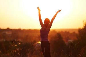 Jeune femme dans le champ d'été du soir photo