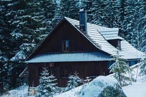 maison en bois en montagne couverte de neige fraîche dans les montagnes d'hiver photo