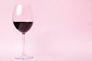 un des lunettes de rouge du vin à du vin dégustation. concept de rouge du vin sur coloré Contexte. Haut voir, plat allonger conception photo