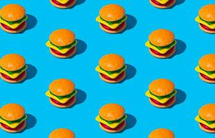 Créatif modèle composition de gros Burger fabriqué de coloré gommeux des sucreries sur bleu Contexte. minimal nourriture concept. savoureux gelée bonbons idée. gommeux des sucreries esthétique. photo