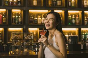 femmes asiatiques buvant des cocktails et s'amusant au bar la nuit. photo