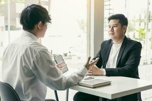 jeune adulte asiatique assis au bureau en face du directeur interviewé entretien d'embauche dans la salle des affaires. photo