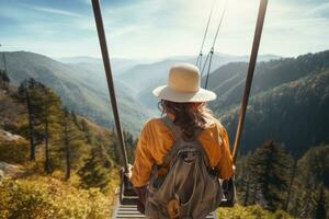 une Jeune femme dans une chapeau et avec une sac à dos est en marchant sur une suspension pont dans le montagnes, promeneur femme équitation une chariot tyrolienne sur le montagne, arrière voir, non visible visages, ai généré photo