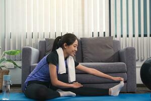 les femmes asiatiques font des exercices d'étirement après avoir suivi des cours de yoga à la maison. photo