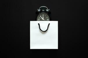 blanc achats papier sac avec alarme l'horloge pour noir Vendredi achats vente concept. photo