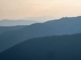 couches de montagnes à le coucher du soleil. doux rose le coucher du soleil dans Montagne paysage. incroyable rose le coucher du soleil avec une silhouette de montagnes. photo