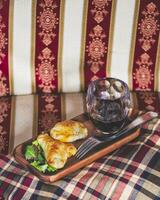 deux Empanadas et une verre de du vin dans une élégant retraite. photo