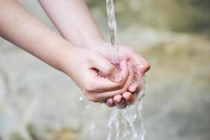 la main attrape les gouttes d'eau qui sortent du robinet photo