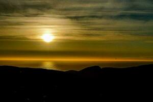 le Soleil réglage plus de le océan dans le distance photo