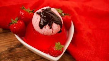 gelée de fraise dans un bol, décorée de crème glacée maison photo