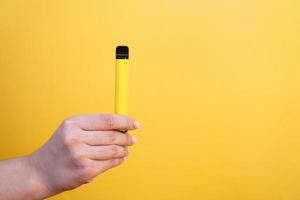 Cigarette électronique jetable jaune en main féminine photo