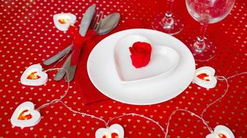 une assiette blanche avec un couteau et une fourchette sur un fond rouge vif photo