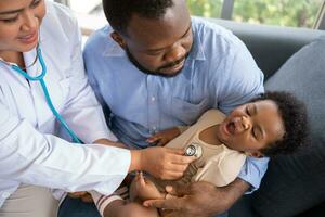 pédiatrie médecin avec stéthoscope pour poumons ou poitrine vérification pour examiner mignonne peu fille dans médical soins de santé hôpital ou clinique. médecin vérifier cœur et poumons pour souriant africain américain bébé. photo