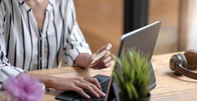 gros plan fille sur internet sur la tablette numérique avec carte de crédit photo