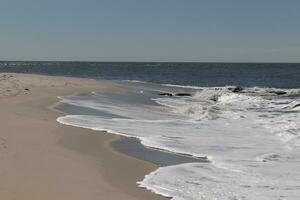 je aimé le Regardez de cette plage scène comme le vagues écrasé dans. le jolie Regardez de le à tête blanche le surf se précipiter dans à le rive. le le sable montrant une différent Ton à où le l'eau une fois était. photo
