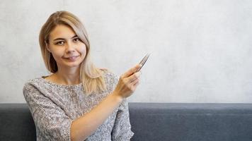 la femme montre avec un stylo sur un mur gris. lieu d'information photo