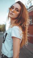mode portrait élégant jolie femme à lunettes de soleil posant dans la ville photo