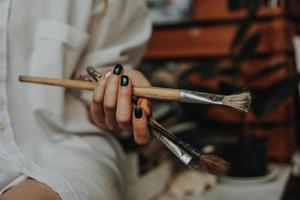 Gros plan de la main de l'artiste féminine tenant un pinceau photo