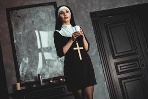 jeune nonne catholique tient une bougie dans ses mains photo