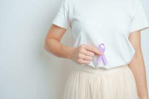 femme ayant estomac et abdomen douleur avec violet ruban pour estomac cancer conscience mois, digestif système, maladie, santé et monde cancer journée concept photo